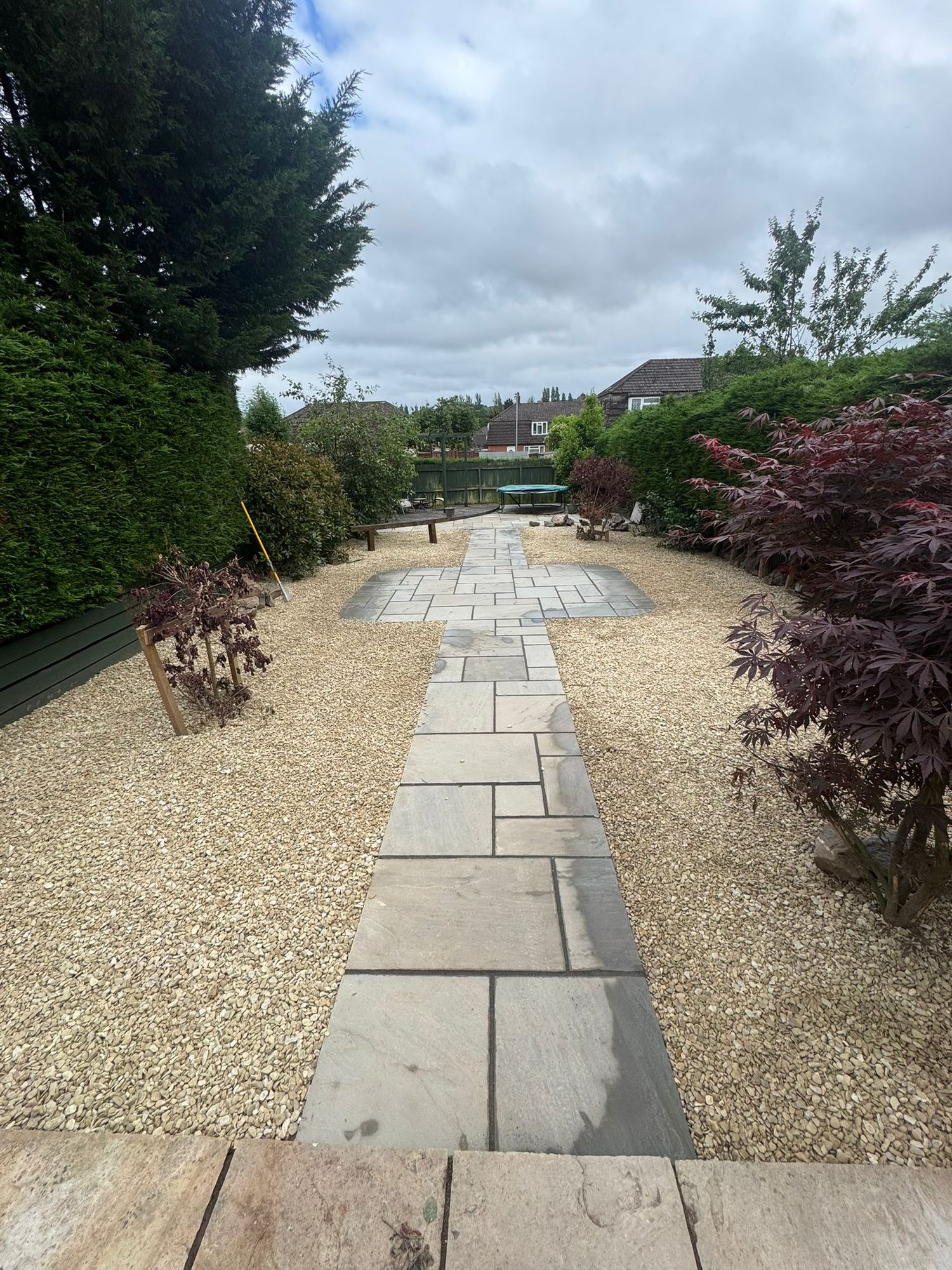 Landscaped garden with a natural stone pathway, gravel beds and new planting