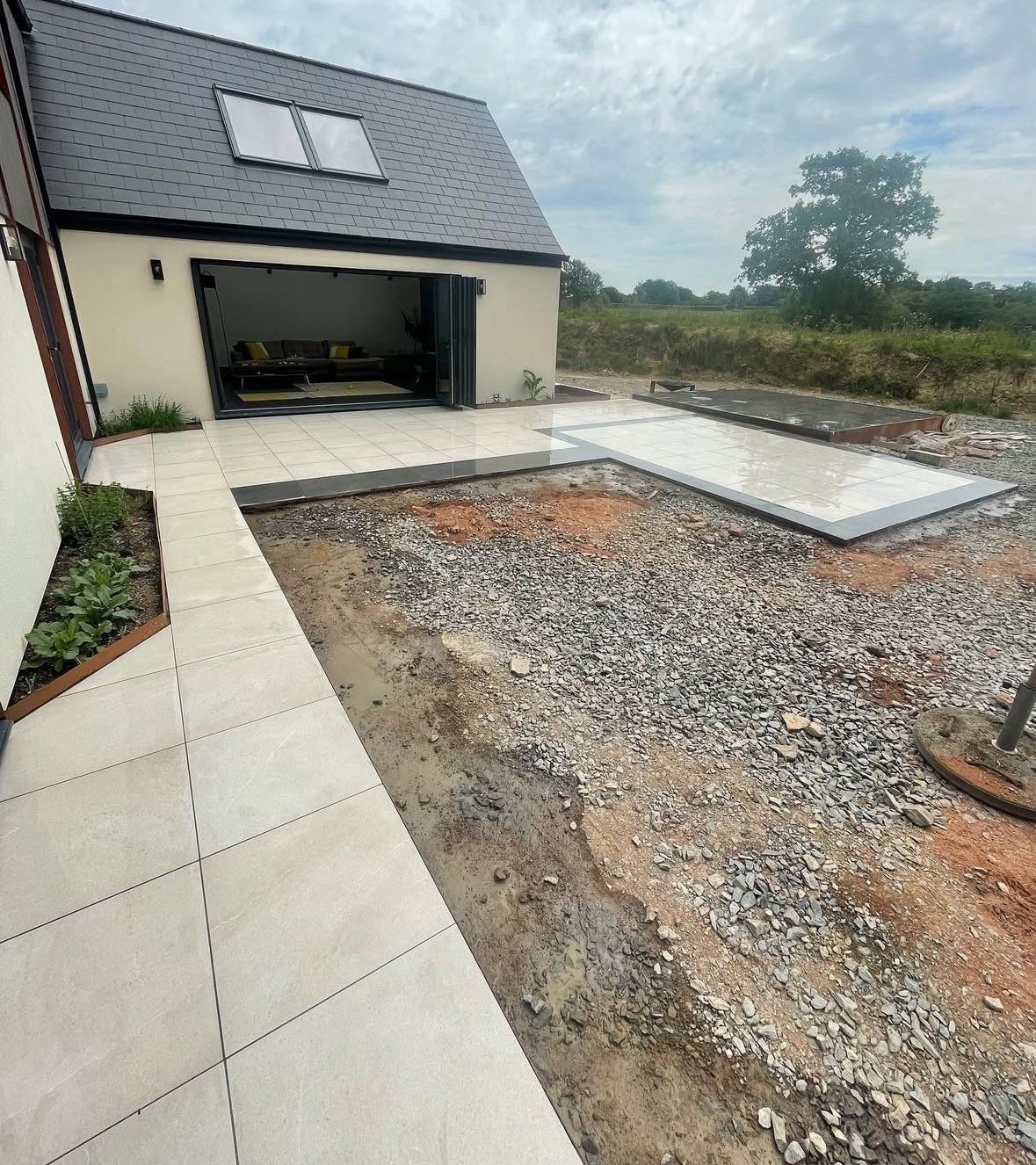Large format porcelain patio laid outside bifold doors on a new build home